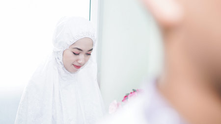 a Muslim family consisting of parents and children prayingの写真素材