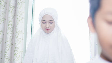 a Muslim family consisting of parents and children prayingの写真素材