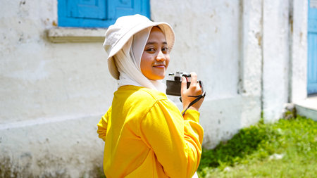 Asian women enjoy smiling travel wearing jilbab and analog camera