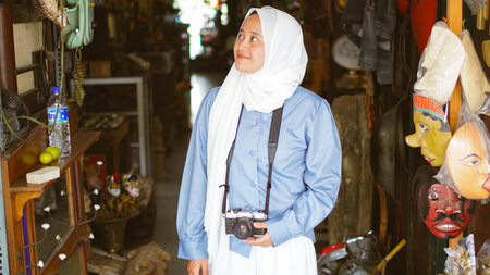 Asian women travel and visit antique shops wearing jilbab and analog cameraの写真素材