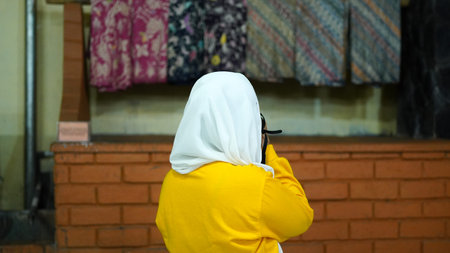 Asian women travel to see batik wearing jilbab and analog cameraの写真素材
