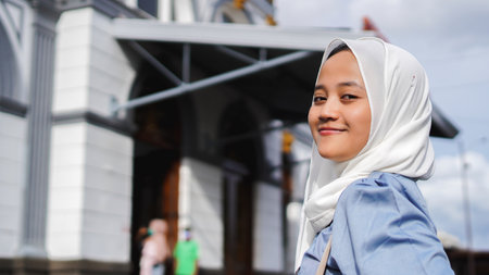 Asian women traveling by train in front of the station wearing jilbab and analog cameraの写真素材