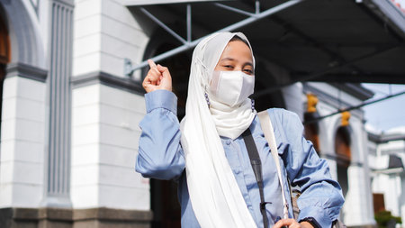 Asian women traveling by train in front of the station wearing jilbab and analog cameraの写真素材