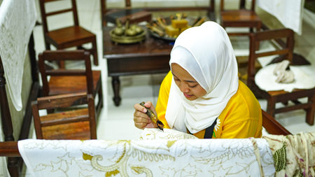 Asian women learn to make batik wearing jilbab and analog cameraの写真素材