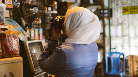 Asian women travel and visit antique shops wearing jilbab and analog cameraの写真素材