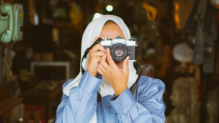 Asian women travel and visit antique shops wearing jilbab and analog cameraの写真素材