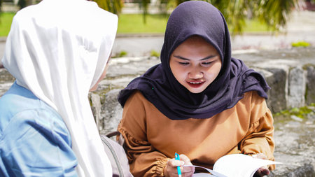 two Asian woman student friends discussing