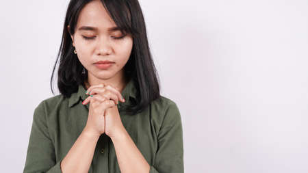 a Christian woman praying humbly isolated white backgroundの写真素材