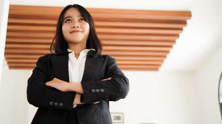 Beautiful young asian business woman in suit standing at cafeの写真素材