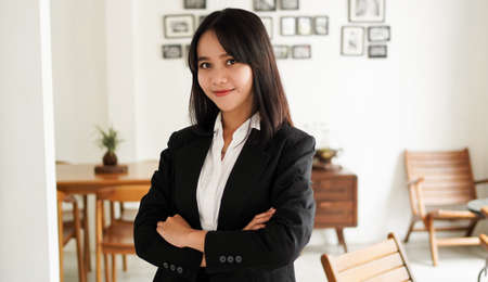 Beautiful young asian business woman in suit standing at cafeの写真素材