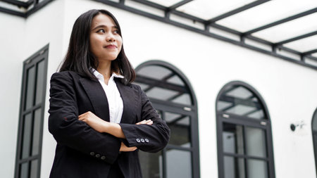 Asian business woman smiling and standing in front office
