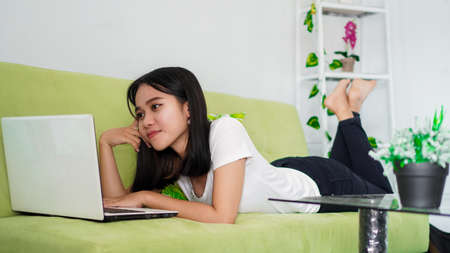 asian women sitting on chair work from home at laptop and thinking of problem solutionの写真素材