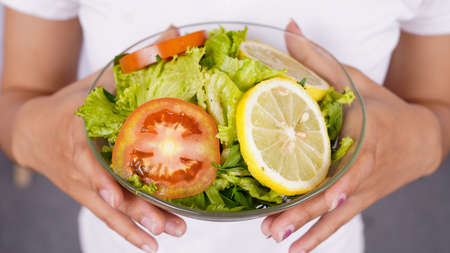 Green salad with tomato, lemon and fresh vegetablesの写真素材