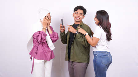 two women and man bulliying one other isolated white backgroundの写真素材