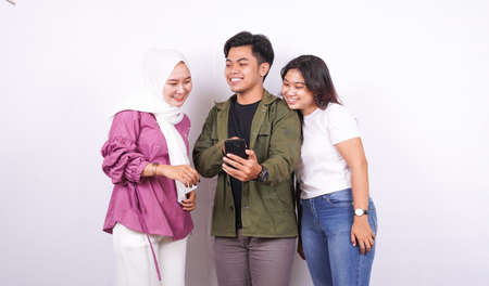 two women and a man are talking with a phone isolated white backgroundの写真素材