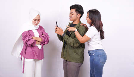 two women and man bulliying one other isolated white backgroundの写真素材
