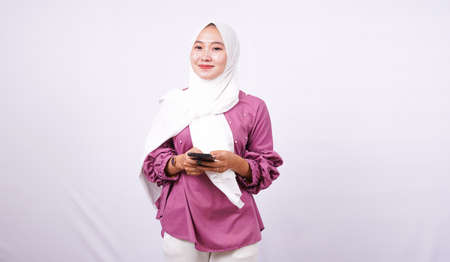 beautiful women hijab holding phone isolated white backgroundの写真素材