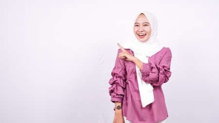 beautiful women hijab pointing blank area on left isolated white backgroundの写真素材