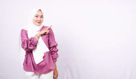 beautiful women hijab pointing blank area on right isolated white backgroundの写真素材