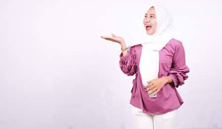 beautiful women hijab pointing blank area on left isolated white backgroundの写真素材