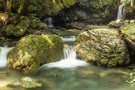 Small waterfall in the forest with big stone in Japanの写真素材