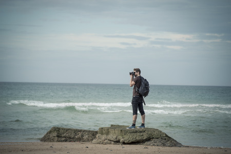 man standing on the rock taking picturesの写真素材
