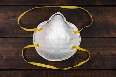 dust mask - respirator on dark brown wooden backgroundの写真素材