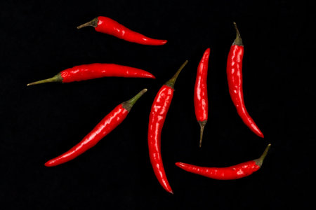 collection of red chili peppers on black background