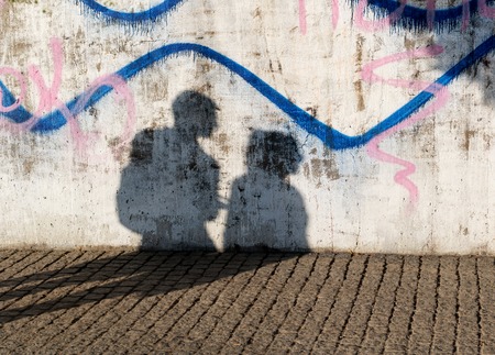 shadow of urban couple on concrete wall with graffitiの写真素材