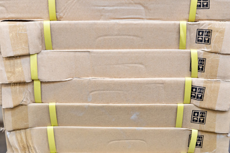 pile of cardboard boxes with yellow tapeの写真素材