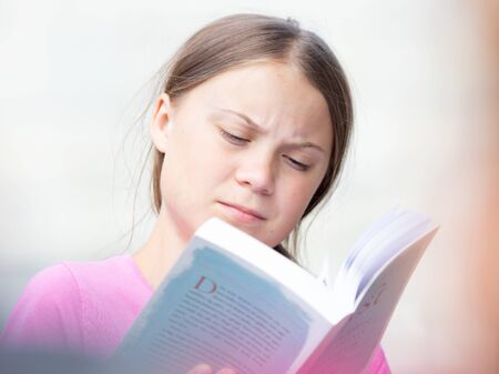 Stockholm, Sweden. 2 August, 2019. 16-year-old Swedish climate activist Greta Thunberg last demonstration in Stockholm on Fridays before going to the US. Realaxing and reading a book.のeditorial素材