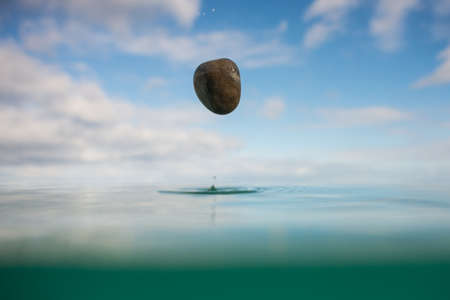 Rock falling into the oceanの写真素材