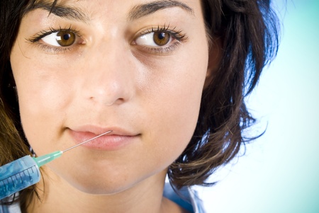 Beautiful woman recieving a botox injection in her lip の写真素材