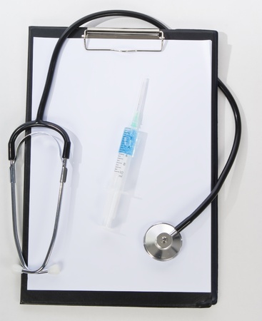 blank clipboard with modern stethoscope and syringeの写真素材