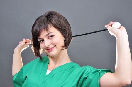Attractive lady doctor on a over gray background の写真素材