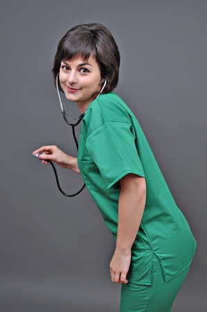 Attractive lady doctor on a over gray background の写真素材
