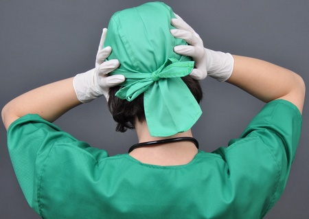 Medical doctor with headache holding her hand to the head, isolated on white の写真素材