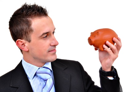 Attractive businessman holding piggy bank. All on white background の写真素材