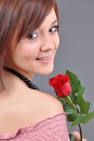 A girl holding a red rose in her hand  の写真素材