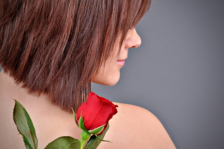 A girl holding a red rose in her hand  の写真素材