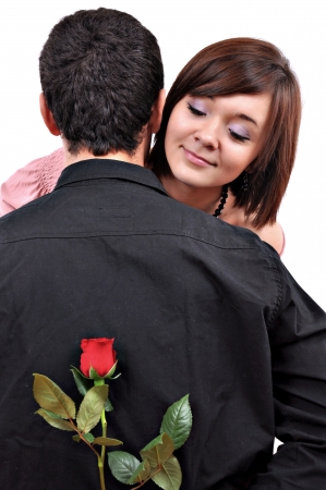 happy beautiful teenage couple, a boy giving a rose to his girlfriendの写真素材