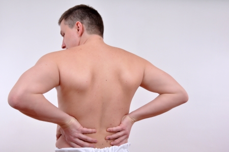 young caucasian man with pain in a back isolated on white の写真素材