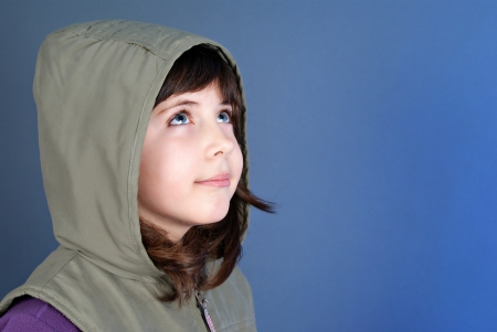 Smiling little child looking up at copyspace isolated on blue background の写真素材