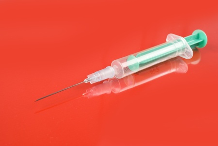 photo of Medical Syringe on red background の写真素材