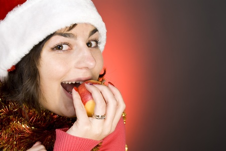 young attractive girl in Santa's suite eating an apple の写真素材