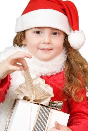 Girl in christmas hat opening a gift の写真素材