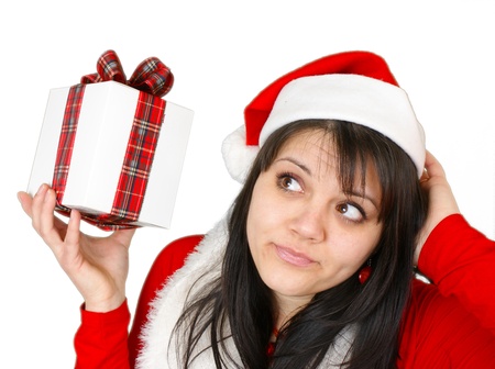 Girl holding a gift and thinking, isolated on white background  の写真素材