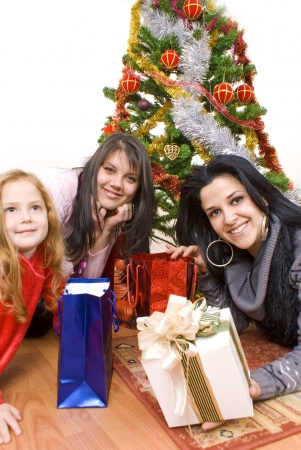Three young happy womenwhit gift box. Studio shot. White background の写真素材