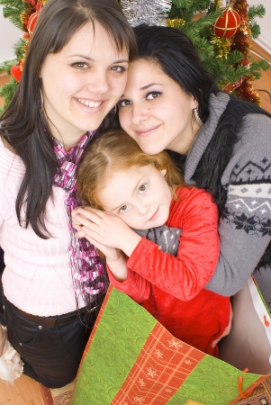 Three young happy womenwhit gift box. Studio shotの写真素材