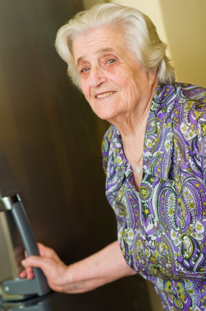 old woman looking for food in the refrigerator の写真素材